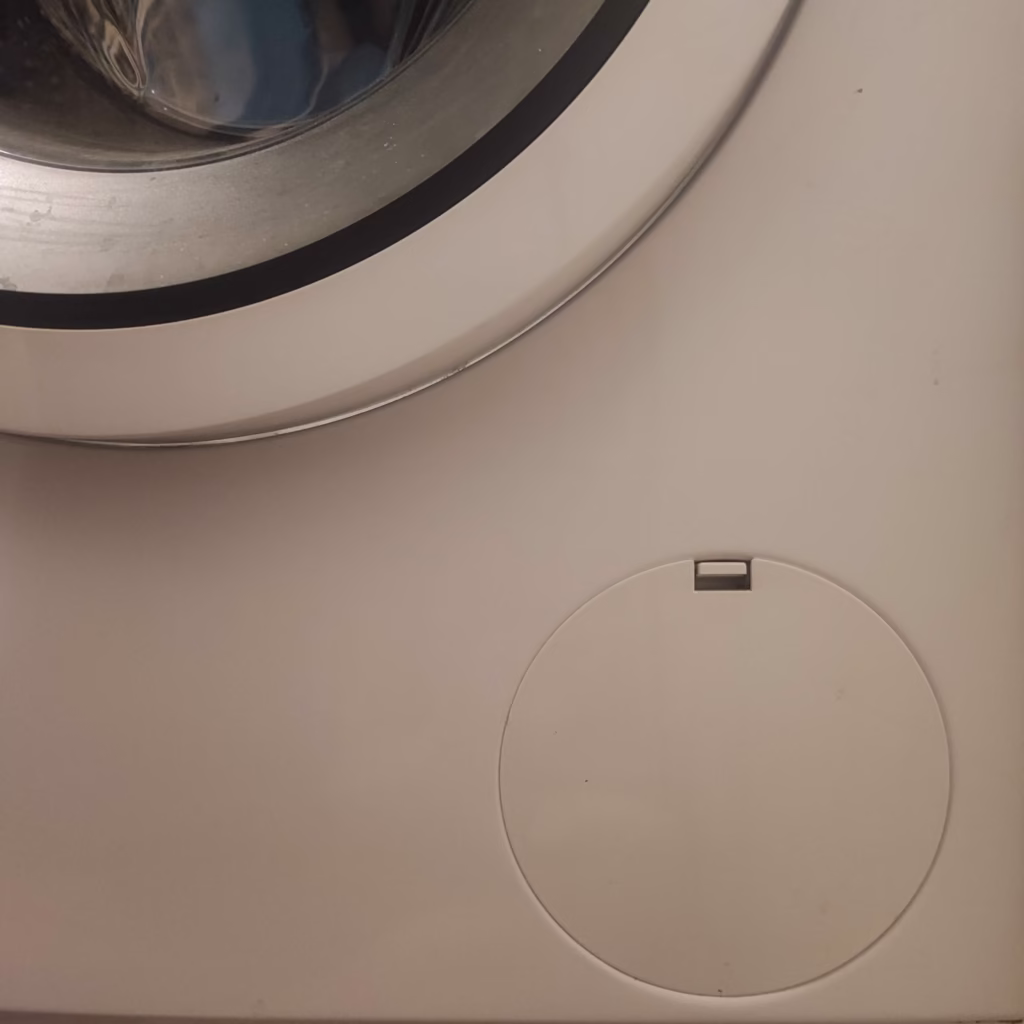 An example of where the washing machine filter could be found. In this shot an opening is displayed at the bottom right corner of the front of the washing machine.