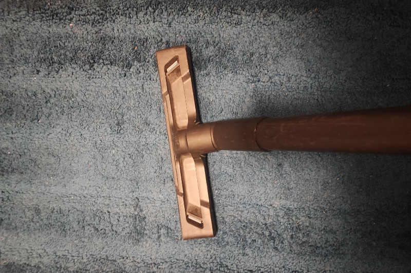 How We Test And Review Our Gear Hands-on product testing showing vacuum being tested on carpet in real-world conditions