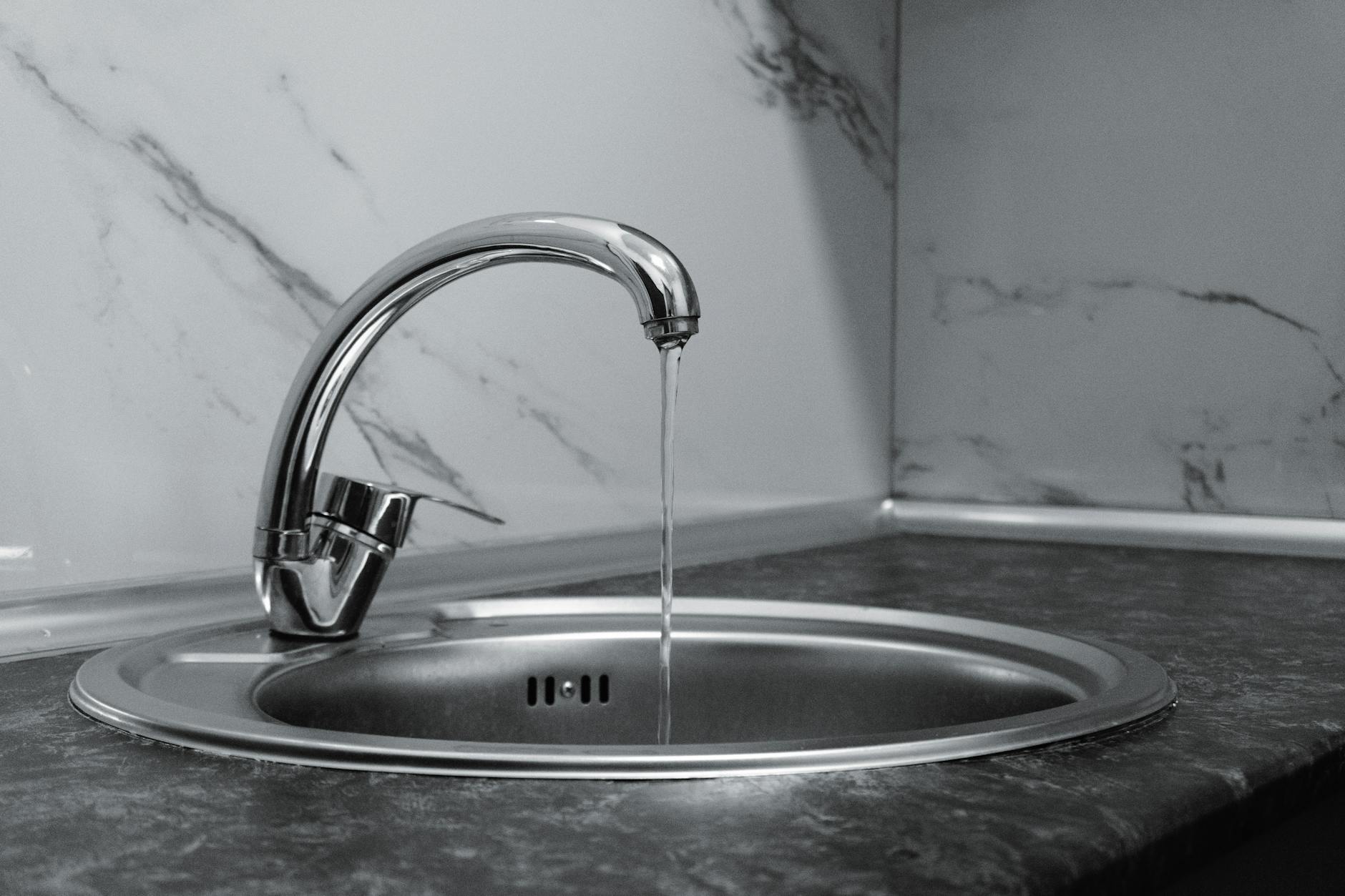 How to Deep Clean Your Kitchen: Full Sequence (2026) A clean stainless steel kitchen sink with faucet polished, no clutter, and a tidy surrounding counter